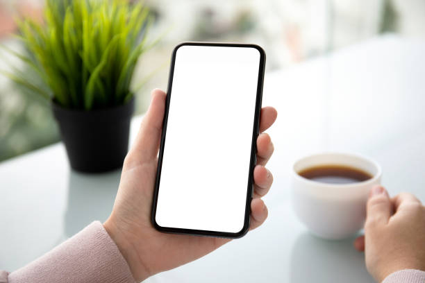 istock female hands holding phone with isolated screen in summer cafe 1150716162