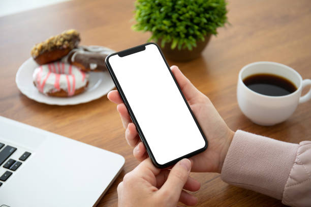 istock female hands holding phone with isolated screen in the office 1150716416