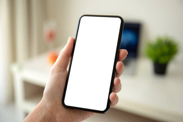 istock female hands holding phone with isolated screen in the room 1150716514