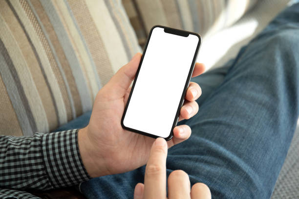 istock male hands holding phone with isolated screen on the sofa 1150718189