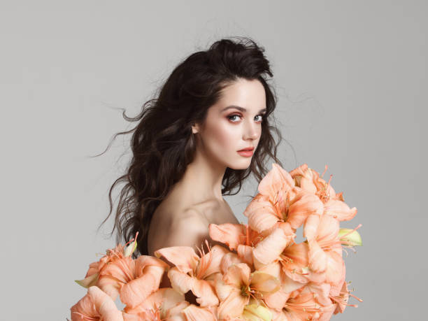 istock Beautiful young woman with flowers 1150719838