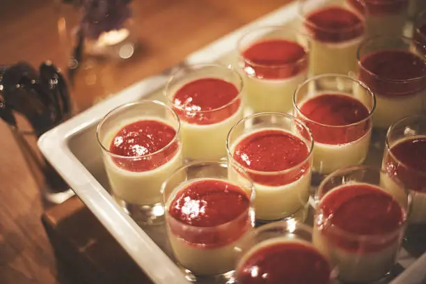 Dessert Pannacotta with strawberry cream on a tray at the table