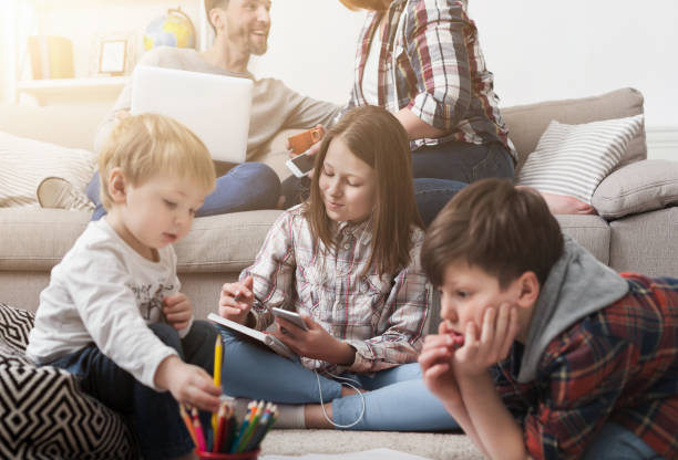 istock Children playing on the floor while parents on sofa 1150725551