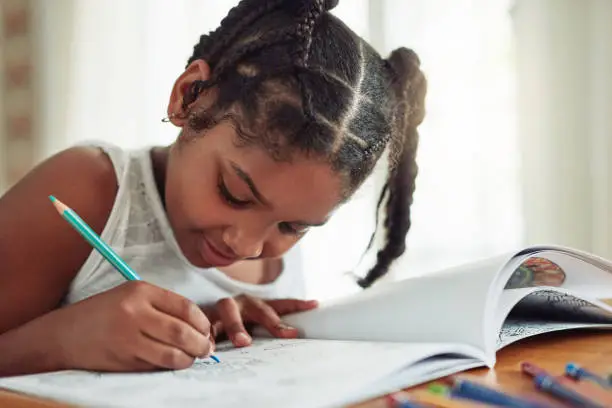 Cropped shot of a young girl coloring in at home