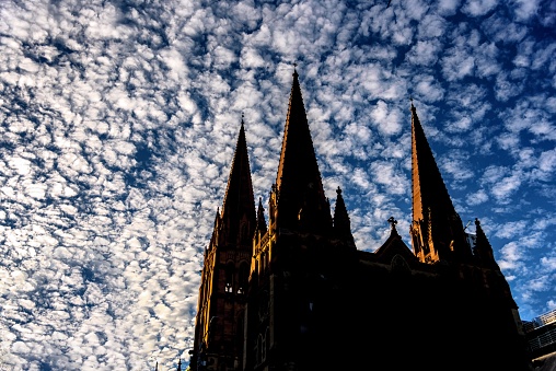 The church spires of St Paul's Cathedral in the city of Melbourne, Australia, set against a dramatic sky