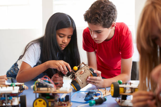 放課後の2人の学生コンピュータコーディングクラスの構築とロボット車両のプログラム学習 - african ethnicity student child group of people ストックフォトと画像