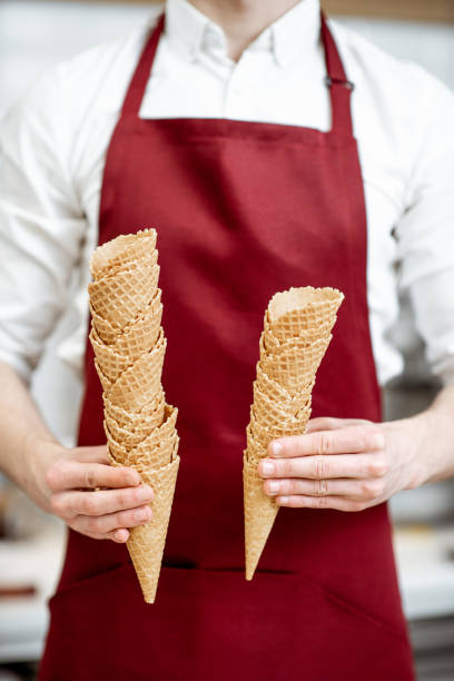 istock Salesman holding waffle cones for ice cream 1150729760