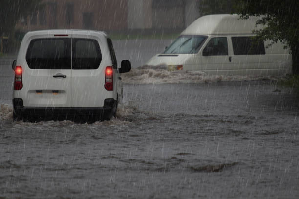 istock Red car rides in heavy rain on a flooded road 1150729894