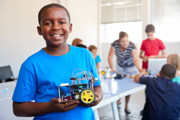 portrait of male student building robot vehicle in after school computer coding class - male african descent africa ethnic imagens e fotografias de stock