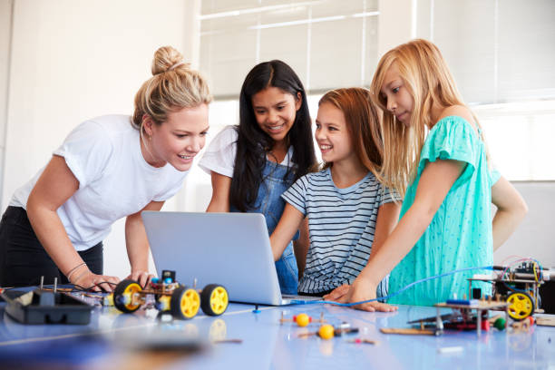 istock Three Female Students With Teacher Building Robot Vehicle In After School Computer Coding Class 1150731171