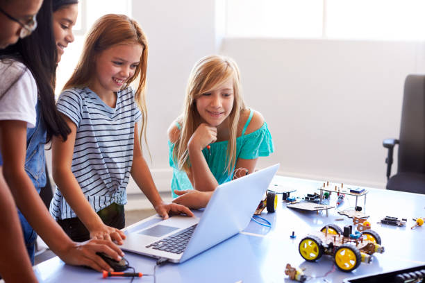 istock Three Female Students With Teacher Building Robot Vehicle In After School Computer Coding Class 1150731175