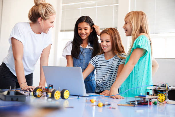 istock Three Female Students With Teacher Building Robot Vehicle In After School Computer Coding Class 1150731217