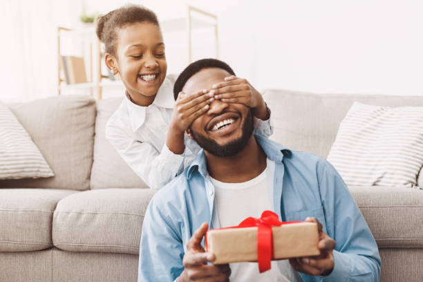 istock Father's day. Happy daughter congratulating dad at home 1150731672