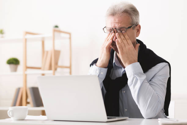 istock Feeling tired. Exhausted senior businessman working on laptop 1150734592