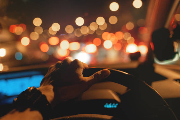 atascado en el atasco de tráfico, la mano izquierda en el volante - car driving dashboard night fotografías e imágenes de stock