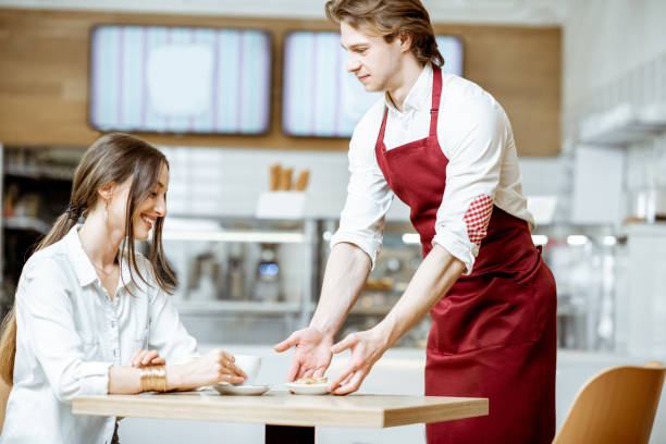 istock Waiter with woman client in the cafe 1150734999