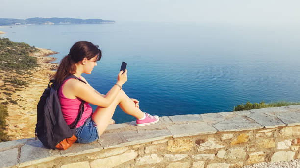 istock Woman messaging and looking seascape 1150736358