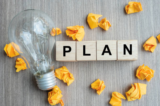 istock PLAN text wood cube and crumbled paper with lightbulb on wooden table background. IDEA, Creative, Innovation, Imagination, inspiration, Solution, Strategy and GOAL concept 1150736634