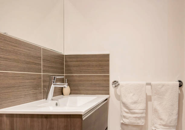 Modern sink in a bathroom with brown wall tiles stock photo