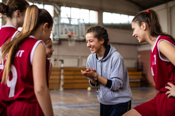 명랑 한 여성 코치와 함께 행복 한 농구 팀 - 농구 팀 스포츠 뉴스 사진 이미지