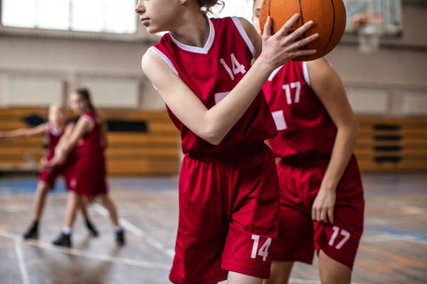 Making some good moves on basketball filed Female basketball team playing match in school gym, dribbling ball on sport filed offense sporting position photos stock pictures, royalty-free photos & images