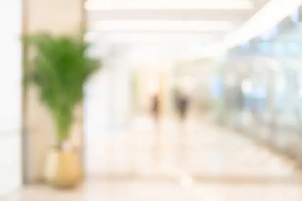 Abstract blur shopping mall corridor. Blurred retail and hall interior in department store. Defocused bokeh effect background or backdrop for business concept.