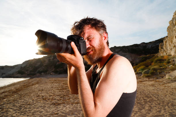 istock Man take pictures on the beach by professional camera 1150739111