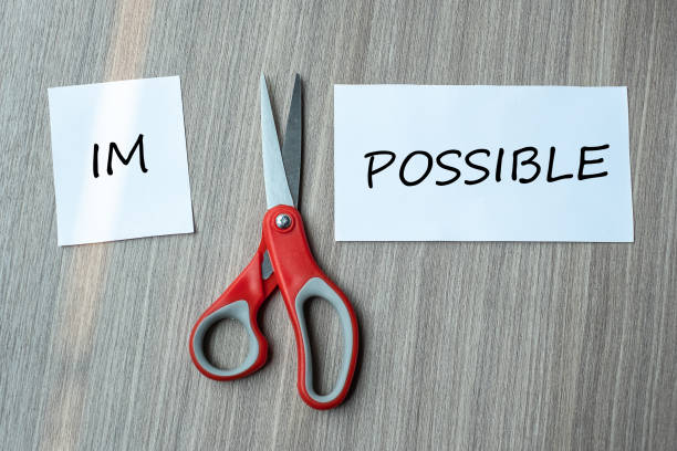 istock red scissors and cutting white paper with the text IMPOSSIBLE, change word to POSSIBLE. challenge, positive thinking and success concept 1150739187