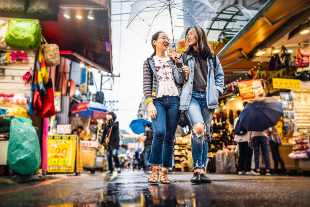 asiatische mädchen, die in einem straßenmarkt spazieren gehen - store market china city street stock-fotos und bilder