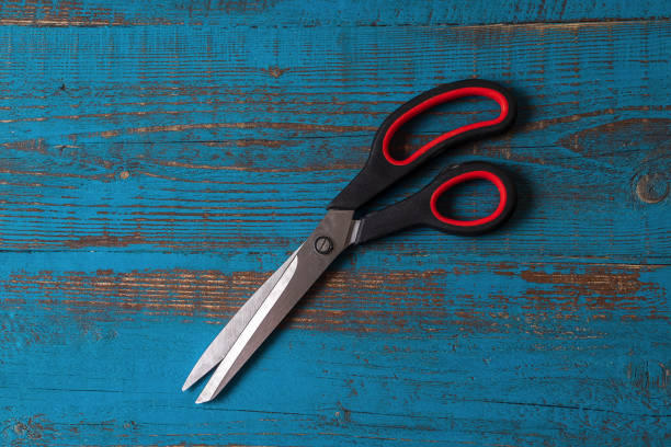 istock A pair of used kitchen scissors against old blue wooden background. 1150741123