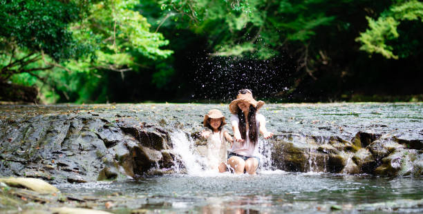 Mother and daughter playing in a mountain stream