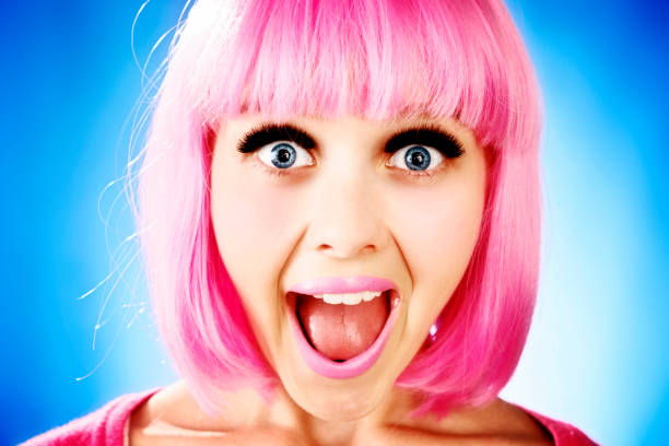 Ragazza adolescente carina in zany parrucca rosa ride e ansima - foto stock