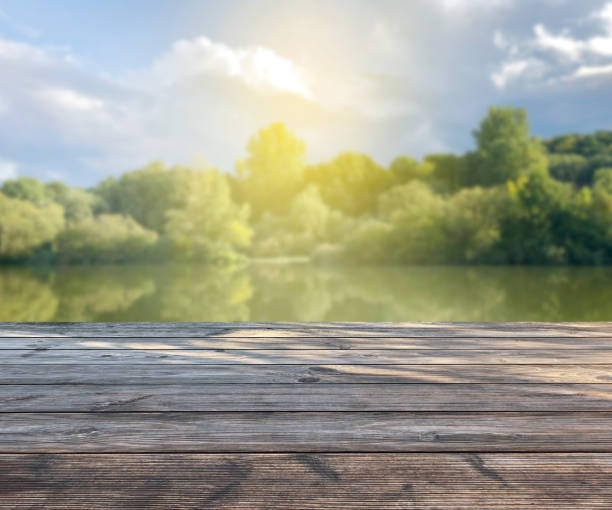 istock spring background with wooden terrace, blurred soft light with see and trees. product display template / presentation. Mock up template for display. 1150748035