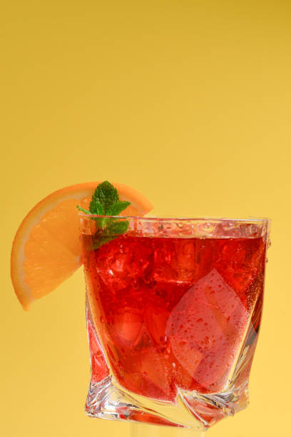 istock Red fresh drink with ice, grapefruit and mint on a yellow background. Space for text or design. 1150748357
