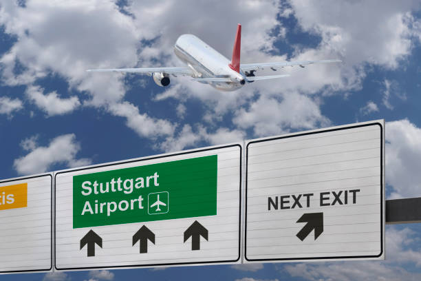 Road sign indicating the direction of Stuttgart airport and a plane that just got up. Road sign indicating the direction of Stuttgart airport and a plane that just got up. landing craft stock pictures, royalty-free photos & images