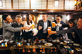 居酒屋日本居酒屋でお祝いのトーストを食べる日本人グループ