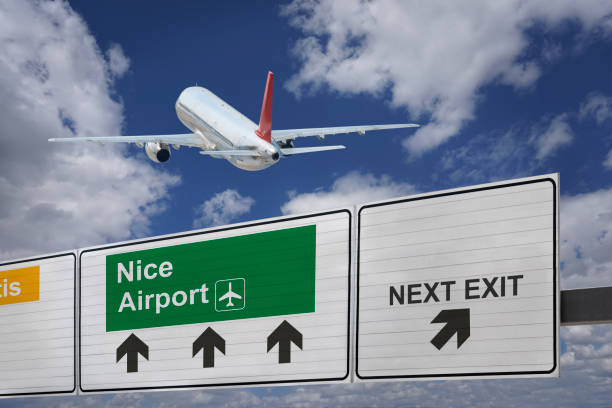 Road sign indicating the direction of Nice airport and a plane that just got up. Road sign indicating the direction of Nice airport and a plane that just got up. landing craft stock pictures, royalty-free photos & images