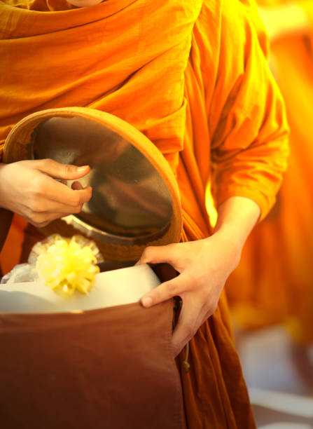 istock monk is offered food by buddhist 1150751193