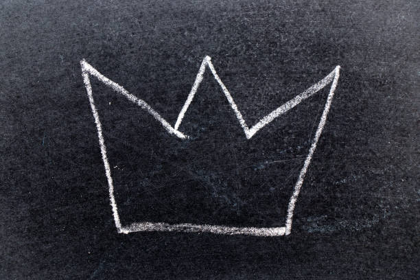 istock White chalk hand drawing in crown shape on black board background 1150753955