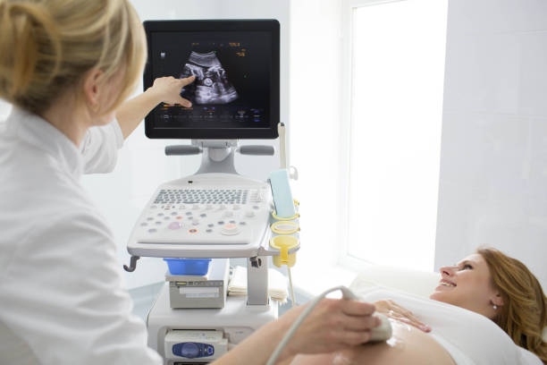 femme enceinte ayant le sonogramme à la clinique. examen échographie patiente enceinte - human pregnancy ultrasound medical exam doctor photos et images de collection