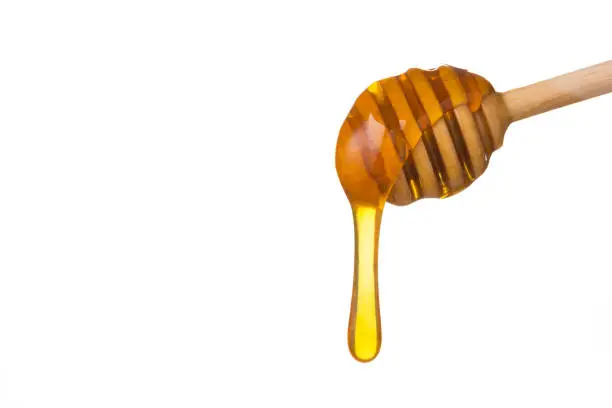 Honey dripping from wooden honey spoon