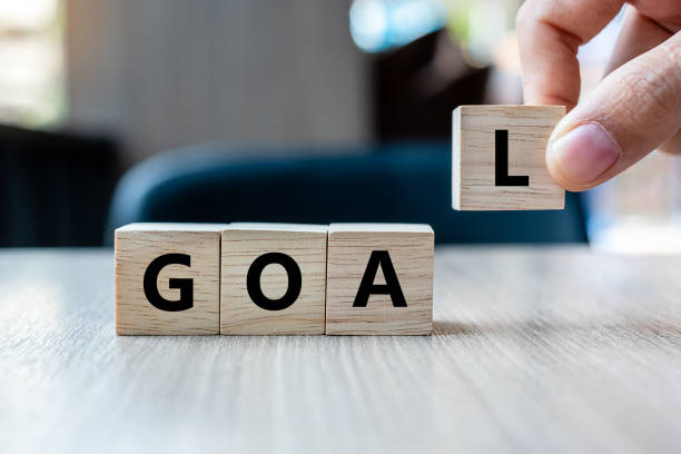 istock Business man hand holding wooden cube with GOAL text on table background. success, strategy, solution and business concepts 1150757744