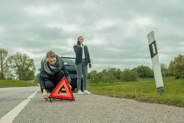 istock Two young women have a car breakdown and secure the vehicle 1150758654