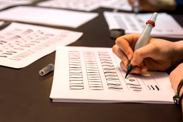 istock Calligraphy workshop. Girl writing calligraphy on postcards, art design 1150758811