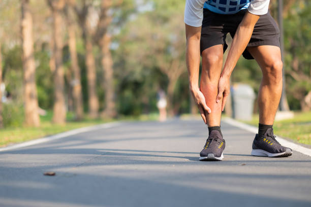 Young fitness man holding his sports leg injury. muscle painful during training. Asian runner having calf ache and problem after running and exercise outside morning. sport and healthy concepts joven fitness hombre sosteniendo su lesión en la pierna deportiva. músculo doloroso durante el entrenamiento. corredor asiático tener dolor de becerro y problema después de correr y hacer ejercicio fuera de la mañana. conceptos deportivos y saludables