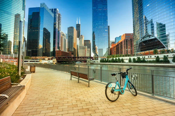 Bike parked along the Chicago Illinois city riverwalk and river The downtown urban city view along the Riverwalk path on the Chicago River in Illinois USA michigan avenue chicago stock pictures, royalty-free photos & images