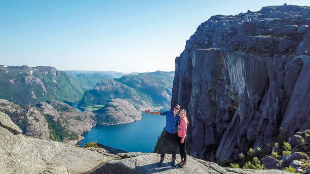 istock Norway - A couple standing on a cliff with a view on Preikestolen 1150764523