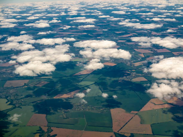 istock Under the clouds green and brown patchwork farming lands and shadows of the clouds 1150766562