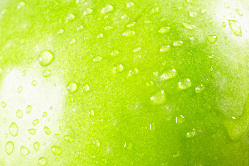 Green apple background in drops.
