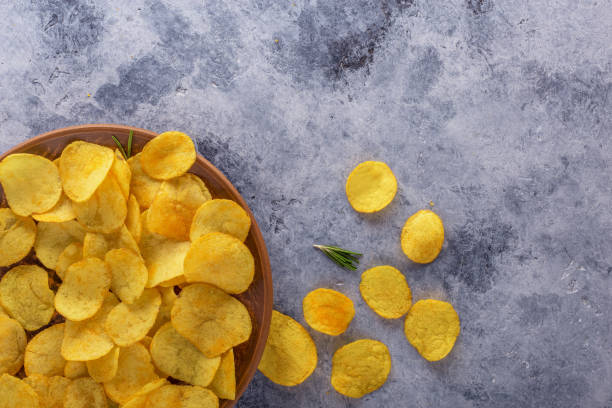 istock Crispy potato chips on the old kitchen table.View from above. 1150769387